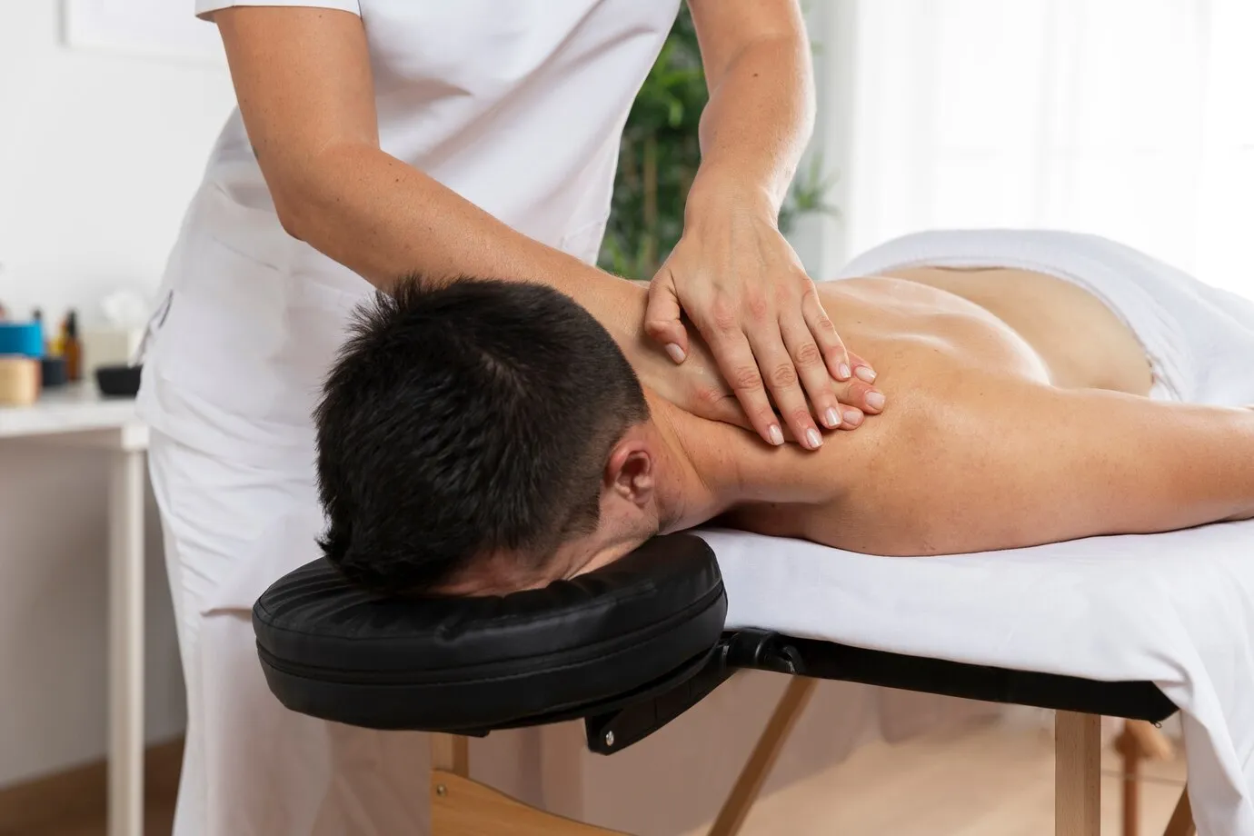 physiotherapist-massaging-patient-office_23-2149143816 (1)
