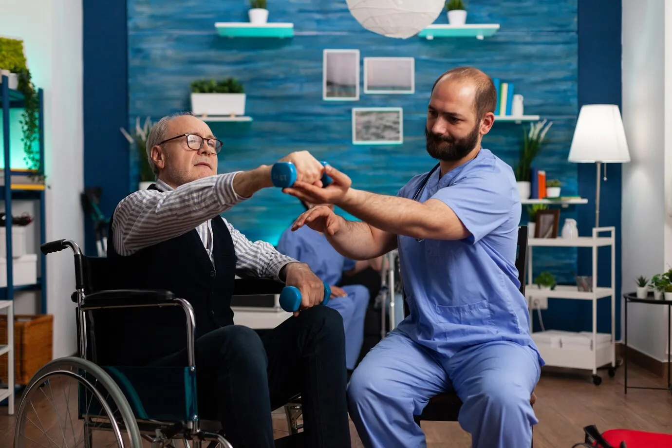 practitioner-man-doctor-helping-retiree-senior-male-wheelchair-physiotherapy-strength-exercise_482257-12761
